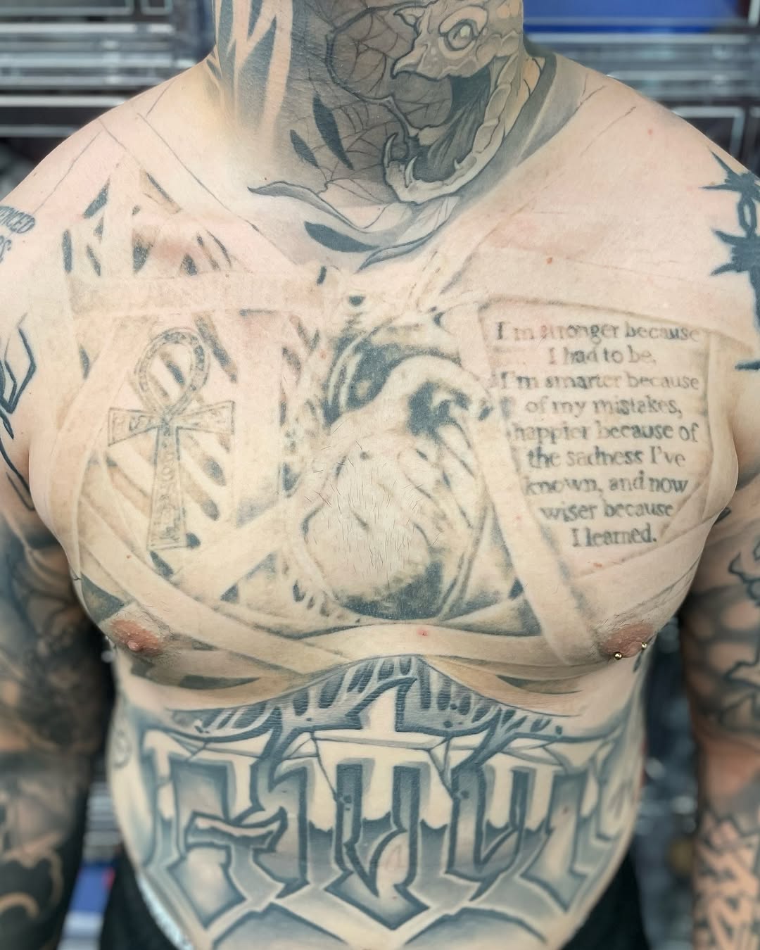 anatomical heart, ankh cross, multi-line script quote and faded neck snake across chest, neck, stomach