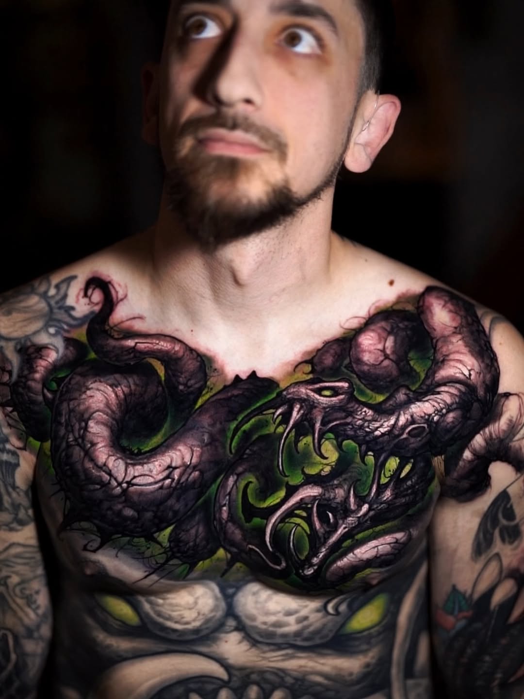 black serpent / dragon snake with green flame negative space across upper chest, integrated with the existing stomach demon